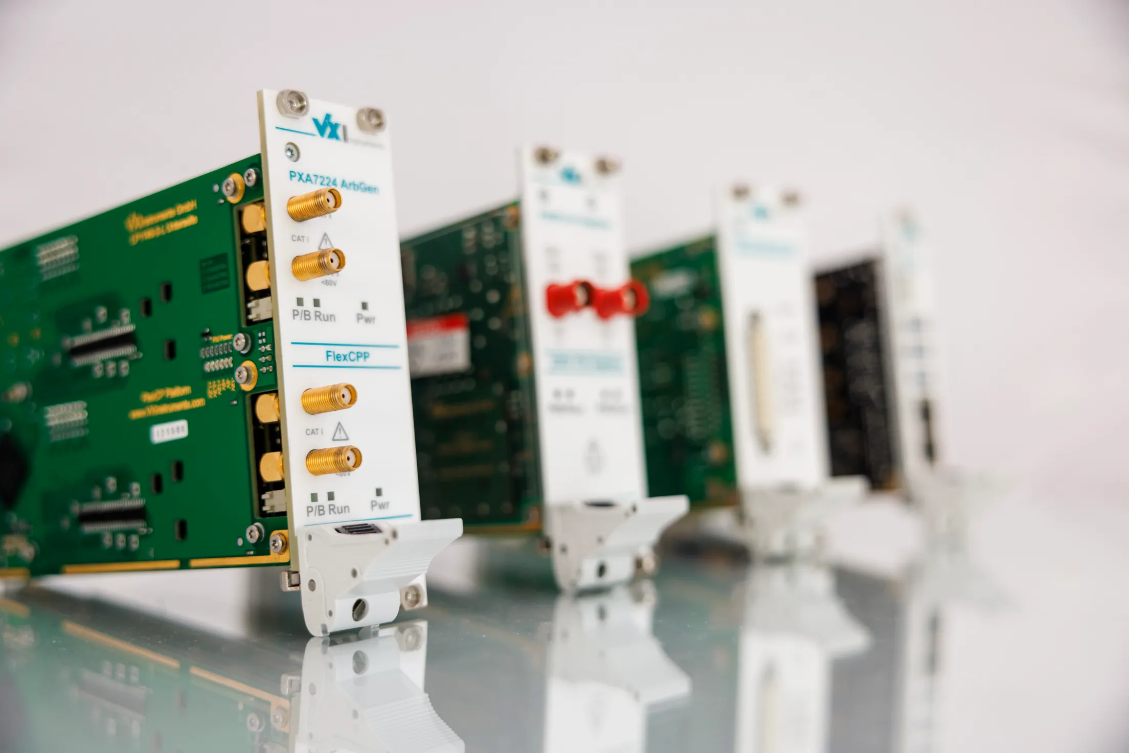 Es sind auf einer glänzenden, hellen Oberfläche vier Messgeräte zu sehen. Sie sind ausgebaut aus dem Gehäuse und nur das erste Gerät ist scharf.